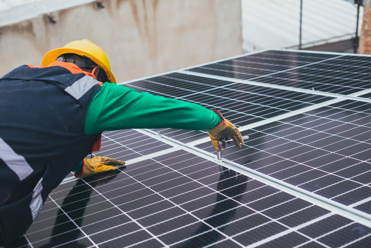A technician installing a solar panel array